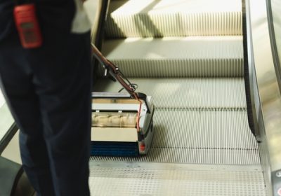 Male,Cleaner,Cleaning,Escalator,With,Mechine,In,Modern,Building.